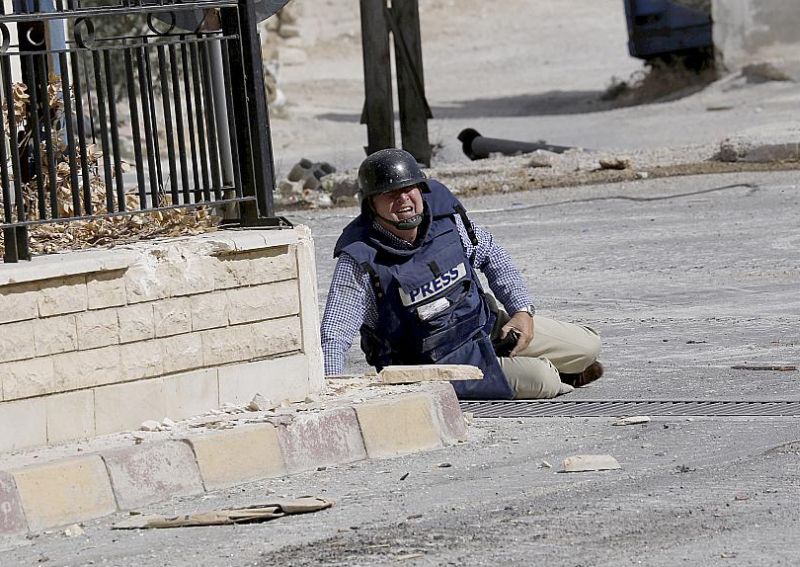 
AFP žurnālists Semijs Kecs pieplacis zemei apšaudes laikā Sīrijas pilsētā Mālulā 2013. gada 18. septembrī.
