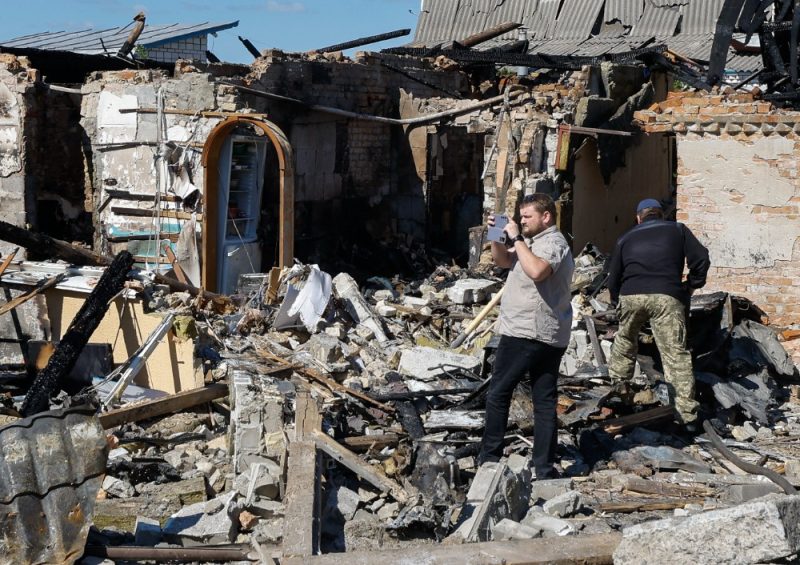 
Cilvēki apskata bojāto privātmāju pēc nakts raķešu uzbrukuma Krasiļivkas ciematā netālu no Kijevas, Ukrainā, 2024.gada 08. maijā, Krievijas iebrukuma laikā. 
